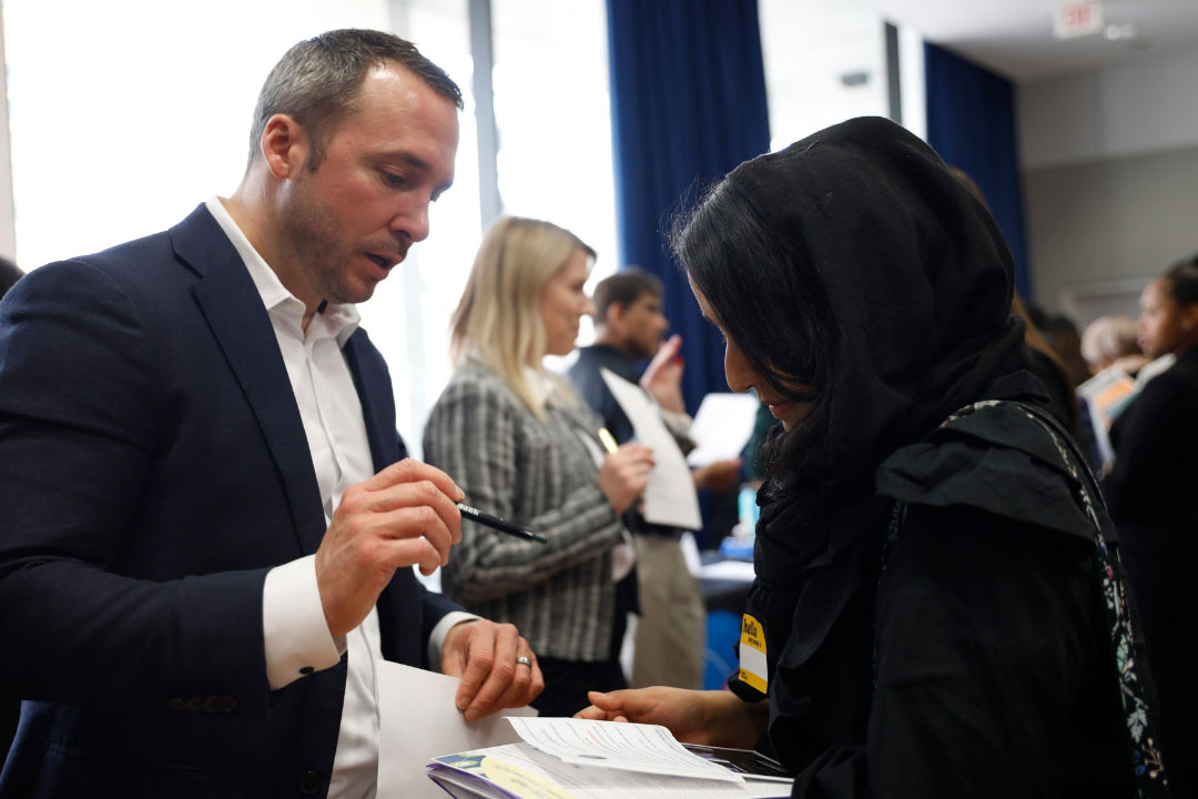 Two people discussing some papers at a networking event